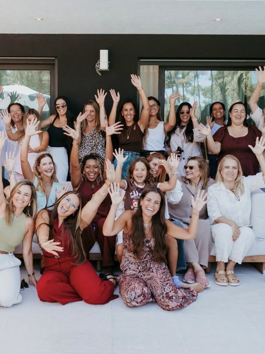 Mulheres do BRAVE celebrando com as mãos para o alto num encontro em Lisboa